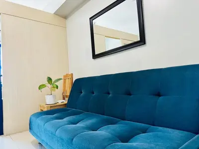 a blue couch in a room with a mirror at Sea Residences in Manila