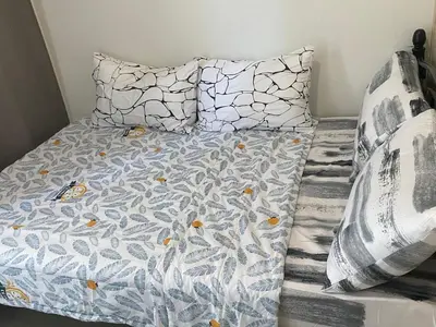 a bed with a blue and white comforter and two pillows at SMDC Jazz Residences in Manila