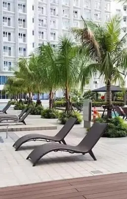 a row of chaise lounges in a park with palm trees at SMDC Jazz Residences in Manila