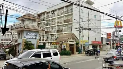 a street with cars parked in front of a building at KASELDORZHOSTEL TRANSIENT at Moonwalk Paranaque in Manila