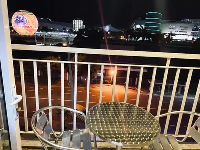 a table and chairs on a balcony at night at Sea Residences - Tino Val in Manila