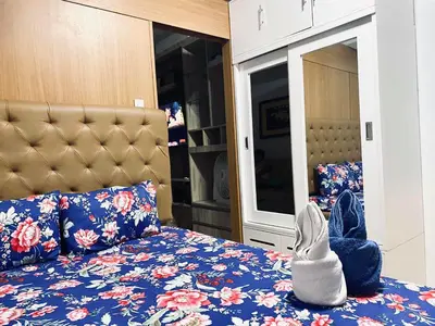 a bedroom with a bed with a blue floral bedspread at Sea Residences - Tino Val in Manila