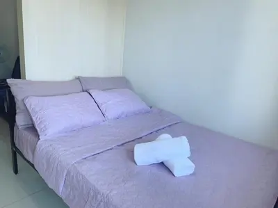 a bed with a towel on top of it at Sea Residences - Tino Val in Manila