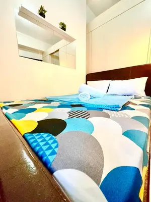 a bedroom with a bed with a colorful bedspread at Sea Residences in Manila