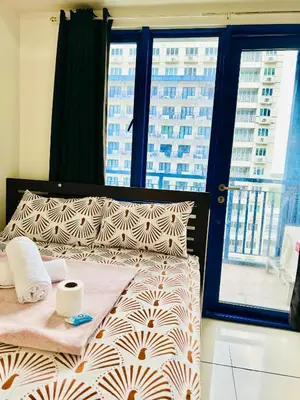 a bed in a room with a large window at Sea Residences in Manila