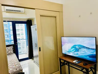 a living room with a flat screen tv on a table at Sea Residences - Val Alano in Manila