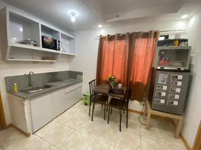 a kitchen with a sink and a table with chairs at Sunmiles Condominium - 2BR unit M26 in Calamba