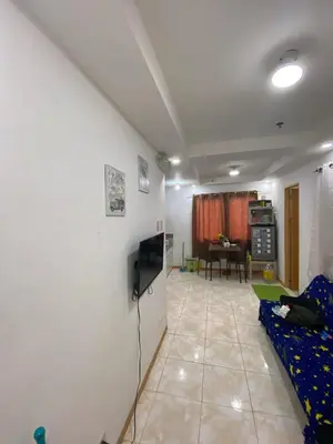 a living room with a couch and a tv at Sunmiles Condominium - 2BR unit M26 in Calamba