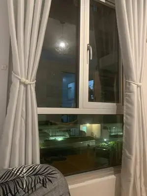 a window with a white curtain in a room at Minimalist 1 Bedroom in Alabang near Molito and ATC with WiFi & Netflix m in Manila