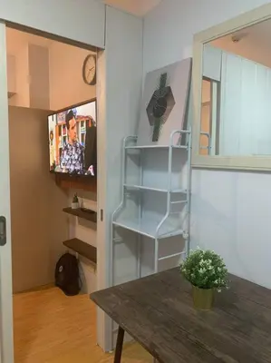 a room with a table and a shelf and a tv at Minimalist 1 Bedroom in Alabang near Molito and ATC with WiFi & Netflix m in Manila