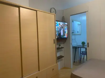 a bedroom with a closet with a tv in it at Minimalist 1 Bedroom in Alabang near Molito and ATC with WiFi & Netflix m in Manila