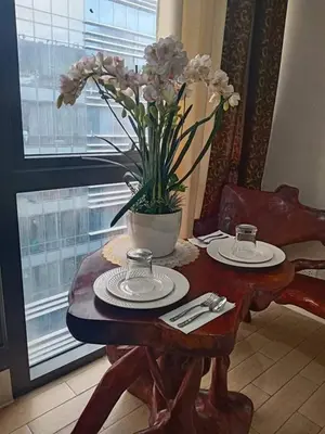 a wooden table with a vase of flowers on it at Cozyvilla at 81 Newport Blvd NEWLY RENOVATED walk to NAIA T3 Marriott & Resorts World Casino & Newport Mall for 5 Pax FREE PARKING!!!! in Manila