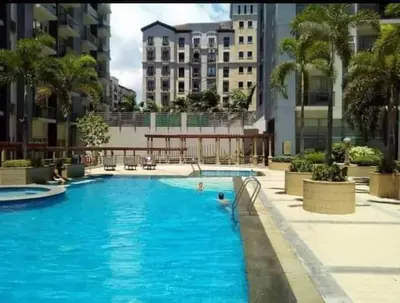 a large swimming pool in a city with buildings at Budget Apartment Manila across Manila Airport T3 in Manila