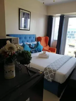 a bedroom with a bed with a vase of flowers on it at Budget Apartment Manila across Manila Airport T3 in Manila