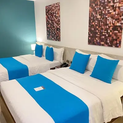 two beds in a room with blue and white at Fynn Boutique Hotel in Bacoor