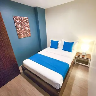 a bedroom with a large bed with blue walls at Fynn Boutique Hotel in Bacoor