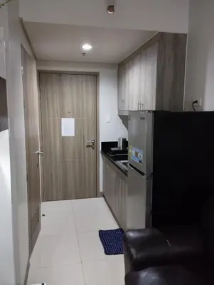 a small kitchen with a refrigerator and a door at Sea Residences MOA by JO Alano New in Manila