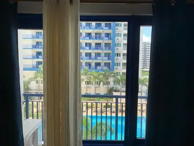 a view of a pool from a hotel room window at Sea Residences MOA by JO Alano New in Manila