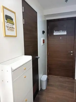 a bathroom with a brown door and a toilet at Fully Furnished 1 Bedroom at SMDC Air Residence with Balcony City View in Manila