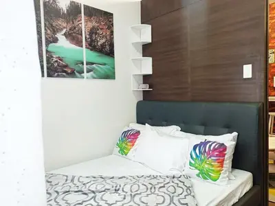 a bedroom with a bed with a picture on the wall at Fully Furnished 1 Bedroom at SMDC Air Residence with Balcony City View in Manila