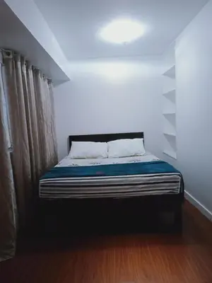 a small bed in a room with a window at 2 Bedrooms Units Forbes Area 5th Avenue BGC Center in Manila