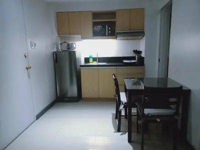 a small kitchen with a table and a refrigerator at 2 Bedrooms Units Forbes Area 5th Avenue BGC Center in Manila