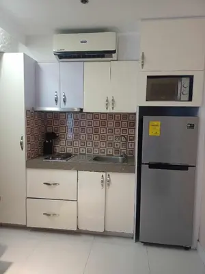 a kitchen with white cabinets and a stainless steel refrigerator at 2 Bedrooms Units Forbes Area 5th Avenue BGC Center in Manila