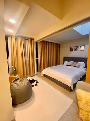 a bedroom with a large bed and a couch at Uptown Parksuites in Manila