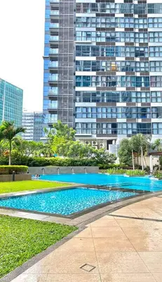 a large swimming pool in front of a tall building at Uptown Parksuites in Manila