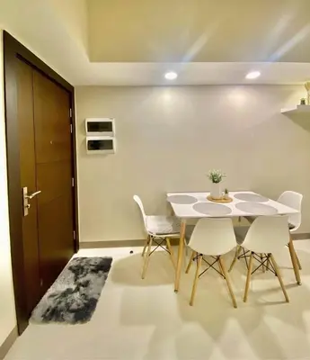 a dining room with a white table and chairs at Uptown Parksuites in Manila