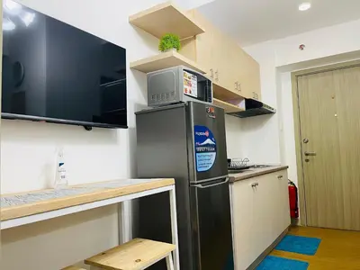 a kitchen with a stainless steel refrigerator with a microwave at Grace Residences 1 Bedroom With Balcony Bgc View Netflix in Manila