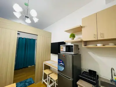 a small kitchen with a refrigerator and a microwave at Grace Residences 1 Bedroom With Balcony Bgc View Netflix in Manila