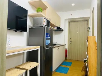 a small kitchen with a refrigerator and a microwave at Grace Residences 1 Bedroom With Balcony Bgc View Netflix in Manila