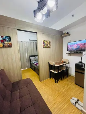 a living room with a couch and a table in a room at Grace Residences 1 Bedroom With Balcony Bgc View Netflix in Manila