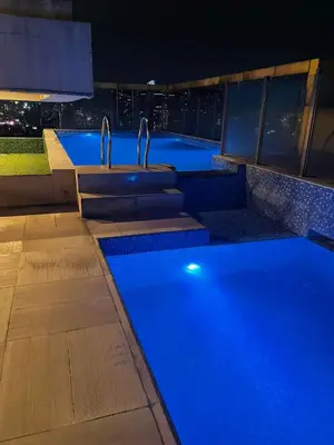 a swimming pool with blue lights on a building at 2 Bedroom Service Apartment In Quezon City in Manila