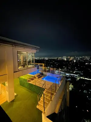 a house with a swimming pool on top of a building at 2 Bedroom Service Apartment In Quezon City in Manila