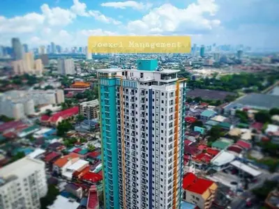 a building with a sign on top of it in a city at 2 Bedroom Service Apartment In Quezon City in Manila
