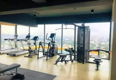 a gym with treadmills and ellipticals in a building at 2 Bedroom Service Apartment In Quezon City in Manila