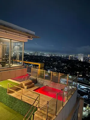 a building with a view of a city at night at 2 Bedroom Service Apartment In Quezon City in Manila