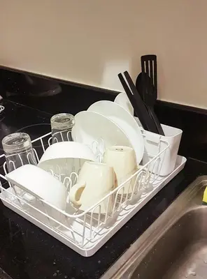 a dish rack full of dishes and utensils on a kitchen counter at StayInMyCondo - 30th Condo in Pasay with Pool near Airport MOA,CCP & PICC In Pasay in Manila