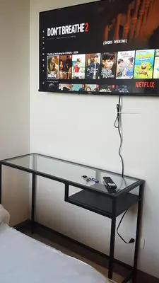 a glass desk with a monitor on a wall at StayInMyCondo - 30th Condo in Pasay with Pool near Airport MOA,CCP & PICC In Pasay in Manila