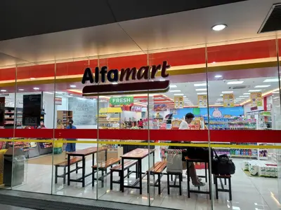 a person sitting at a table in front of a store at StayInMyCondo - 30th Condo in Pasay with Pool near Airport MOA,CCP & PICC In Pasay in Manila
