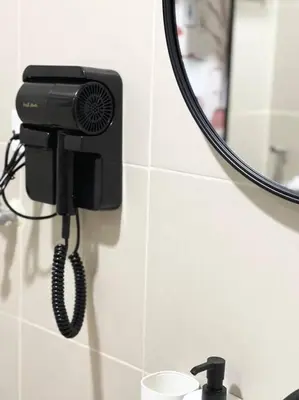 a phone on a bathroom wall with a mirror at 1BR Suite near Megamall, Boni & Shaw MRT Station in Manila