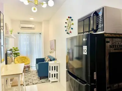 a kitchen and living room with a refrigerator and a couch at 1BR Suite near Megamall, Boni & Shaw MRT Station in Manila