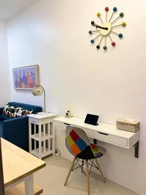 a room with a desk and a clock on the wall at 1BR Suite near Megamall, Boni & Shaw MRT Station in Manila