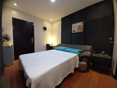 a bedroom with a large white bed and a black wall at Adorable - Hot tub in Manila