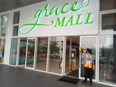 a person standing outside of a glass mall at Apad@graceresidences nr BGC in Manila