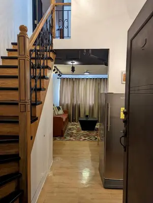 a hallway with a staircase and a living room at Budget 1BR Loft Apartment in Cainta Cambridge Village in Cainta