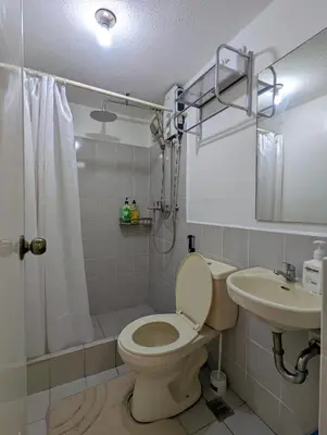 a bathroom with a toilet and a sink and a shower at Budget 1BR Loft Apartment in Cainta Cambridge Village in Cainta