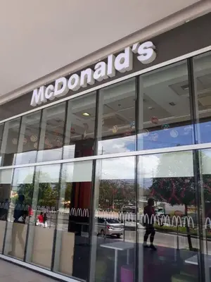 a man walking in front of a macdonalds store at ZG-150Newport in Manila